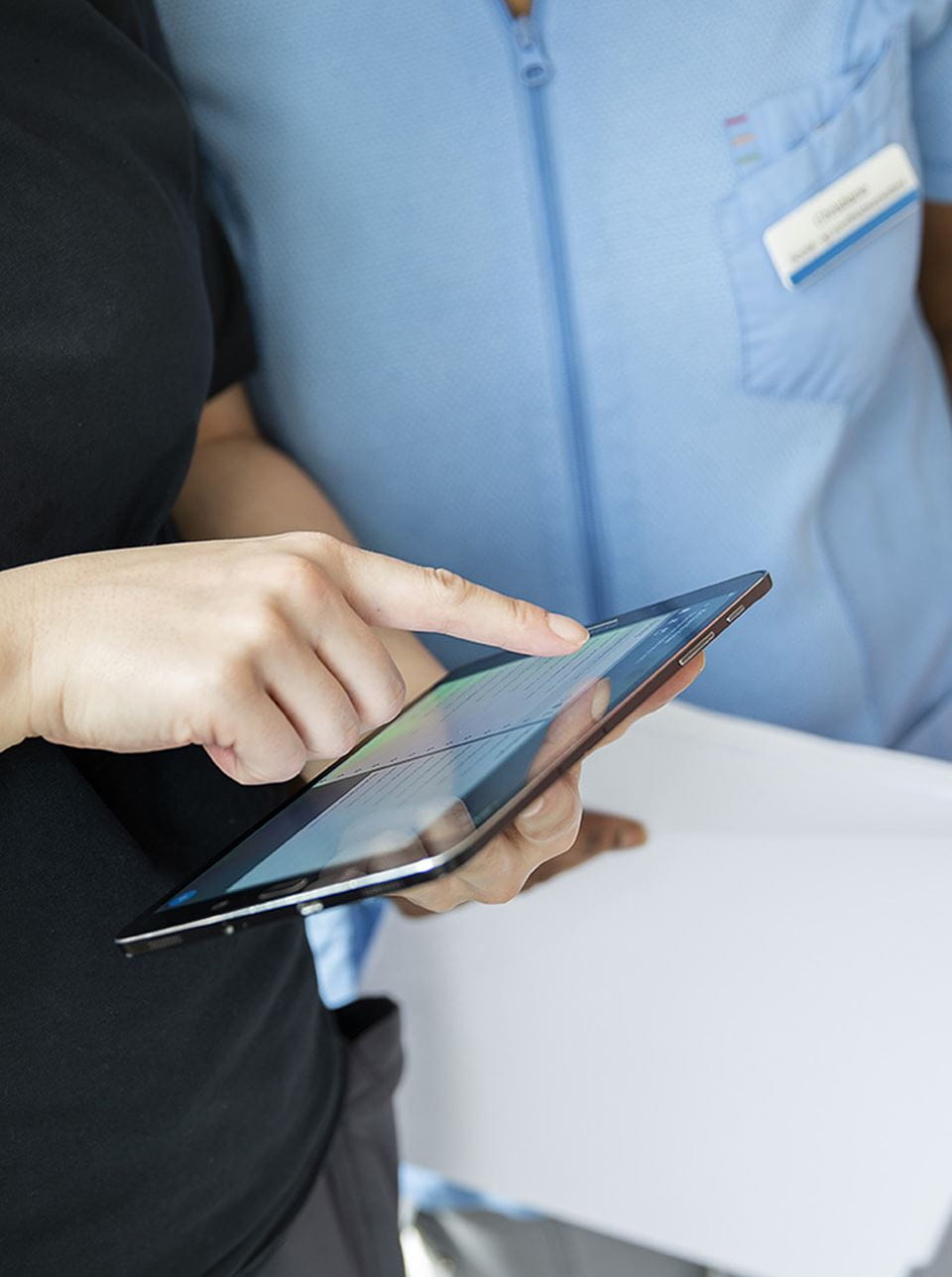 Hjælpere kigger sammen på en tablet-skærm